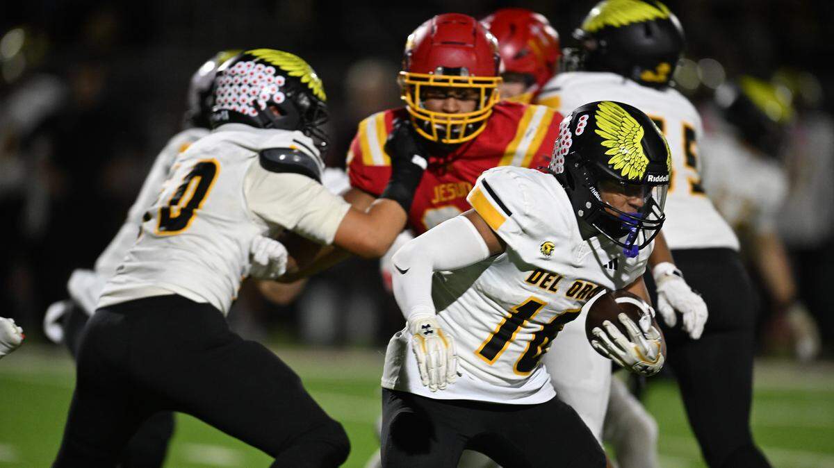 Brandon Alfonso (16) of the Del Oro Golden Eagles runs through the Jesuit Marauders' defense on Friday in Carmichael. Alfonso scored the team’s final two touchdowns.