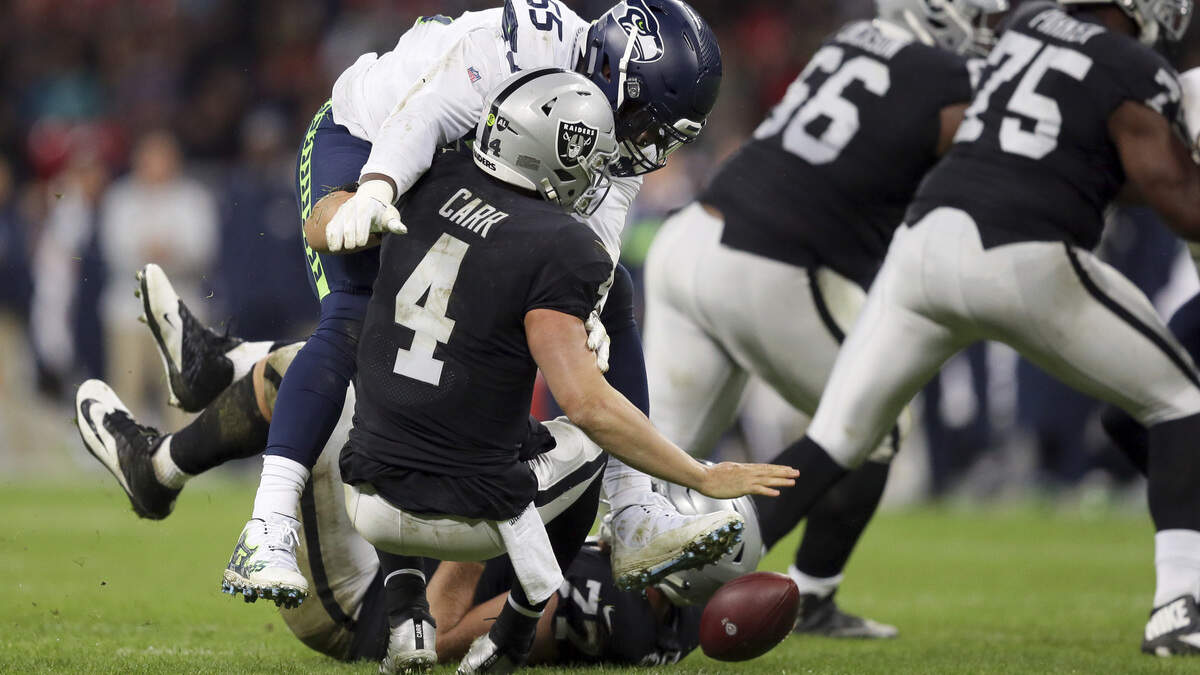 Seattle Seahawks defensive end Frank Clark (55) sacks Raiders quarterback Derek Carr on Sunday in London. Carr was sacked six times in the Raiders’ 27-3 loss.