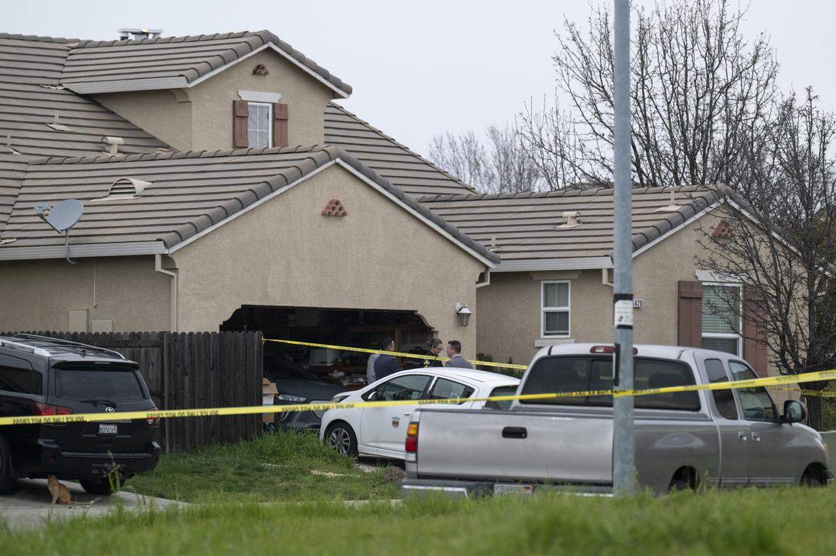 Law enforcement officers investigate a crime scene at a home on Mill Water Circle in Rancho Cordova where four people were found shot to death on Tuesday.