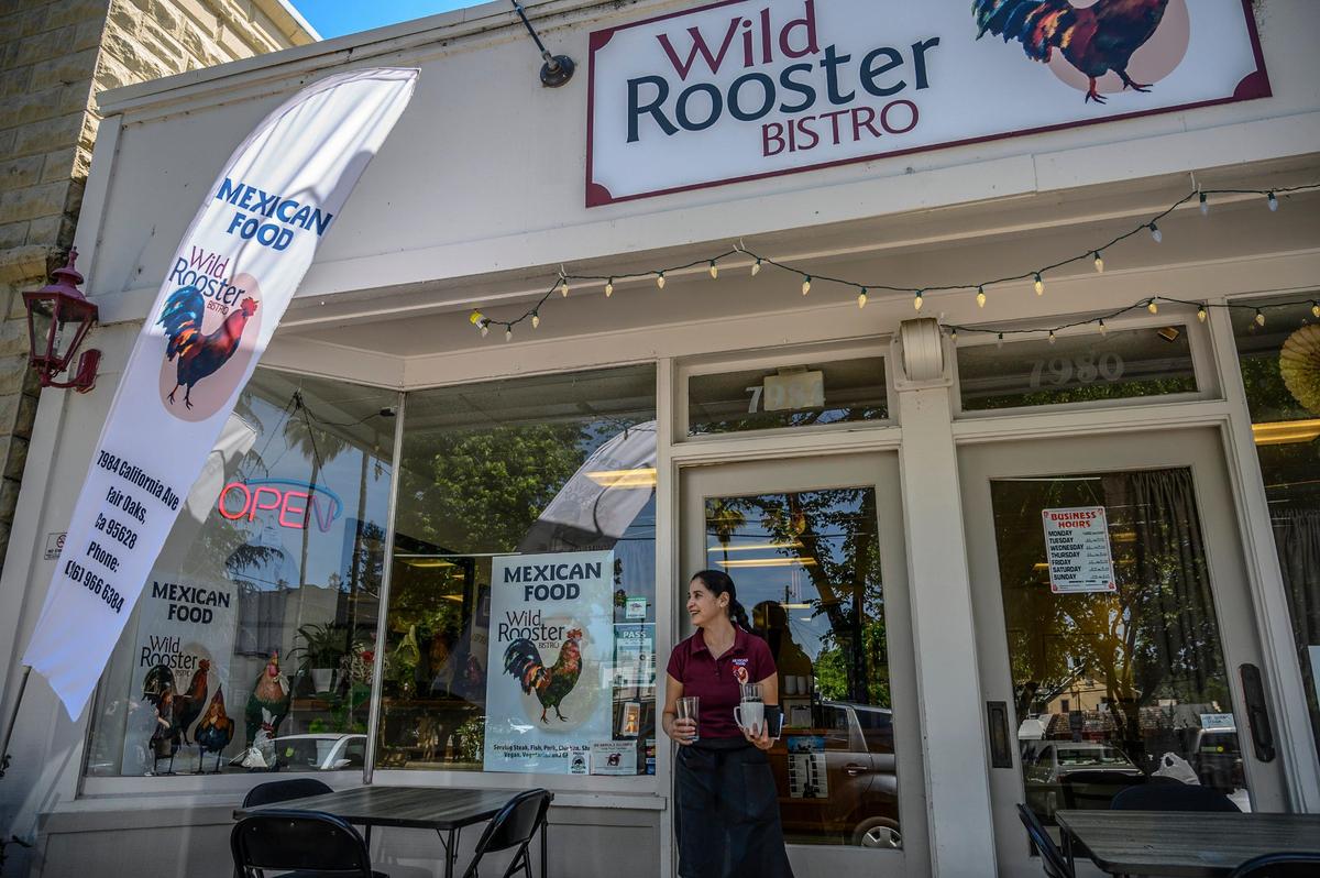 Lorena Van Rein co-owner of Wild Rooster Bistro in Fair Oaks clears a table on Friday, May 10, 2019