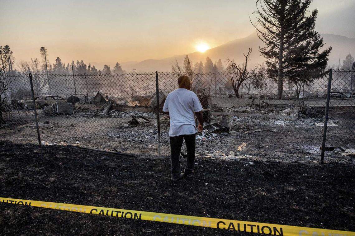 Dave Rodgers surveys his home, destroyed by the Mill Fire, on Saturday in Weed. Rodgers, who lived in the house his entire life, was able to take an elderly neighbor with him as he fled the fast-moving blaze but has not been able to find his two dogs that were left behind.