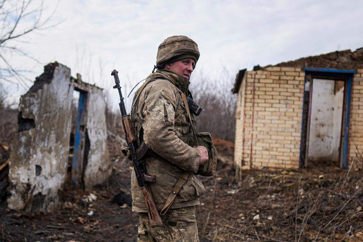 A Ukrainian serviceman stands at his position at the line of separation between Ukraine-held territory and rebel-held territory near Svitlodarsk, eastern Ukraine, Wednesday, Feb. 23, 2022. U.S. President Joe Biden announced the U.S. was ordering heavy financial sanctions against Russia, declaring that Moscow had flagrantly violated international law in what he called the “beginning of a Russian invasion of Ukraine.”