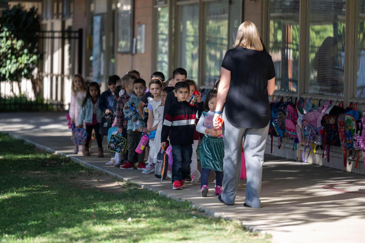 Shannon Faltermier, maestra de preescolar de transición en la Primaria Thomas Kelly, acompaña a sus alumnos al patio de recreo, en octubre.