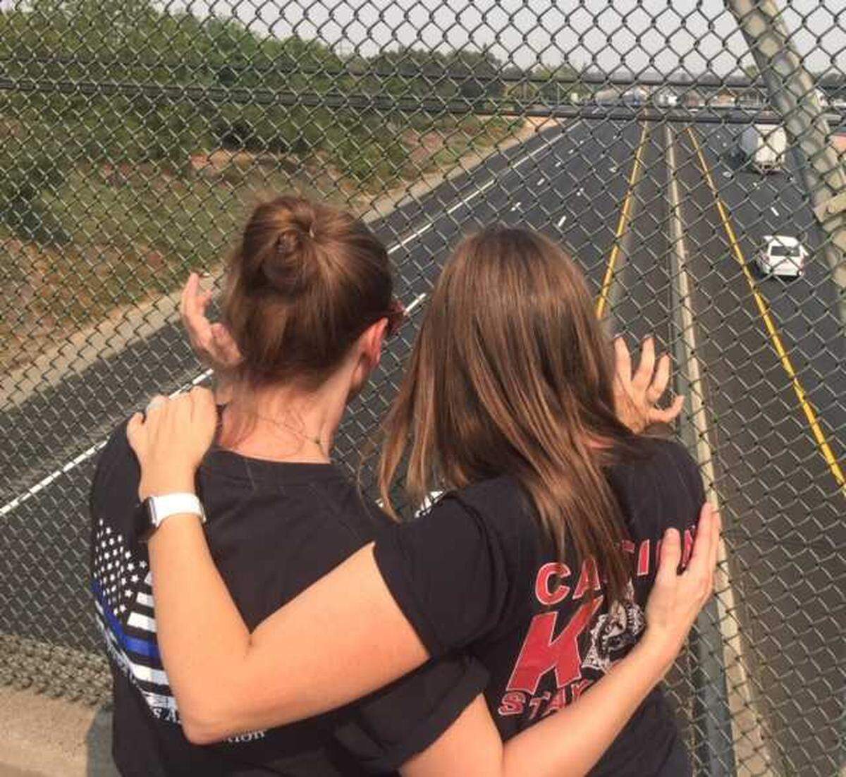 Two women look out at Highway 99 from the Elk Grove Boulevard overpass Aug. 27, 2021, as they await the procession carrying the body of Galt police Officer Harminder Grewal from Kaiser Permanente South Sacramento Medical Center in Sacramento. Grewal died of injuries suffered in a traffic collision on Highway 99 near Dillard Road Aug. 22, as he and his partner traveled to assist with the Caldor Fire in El Dorado County.