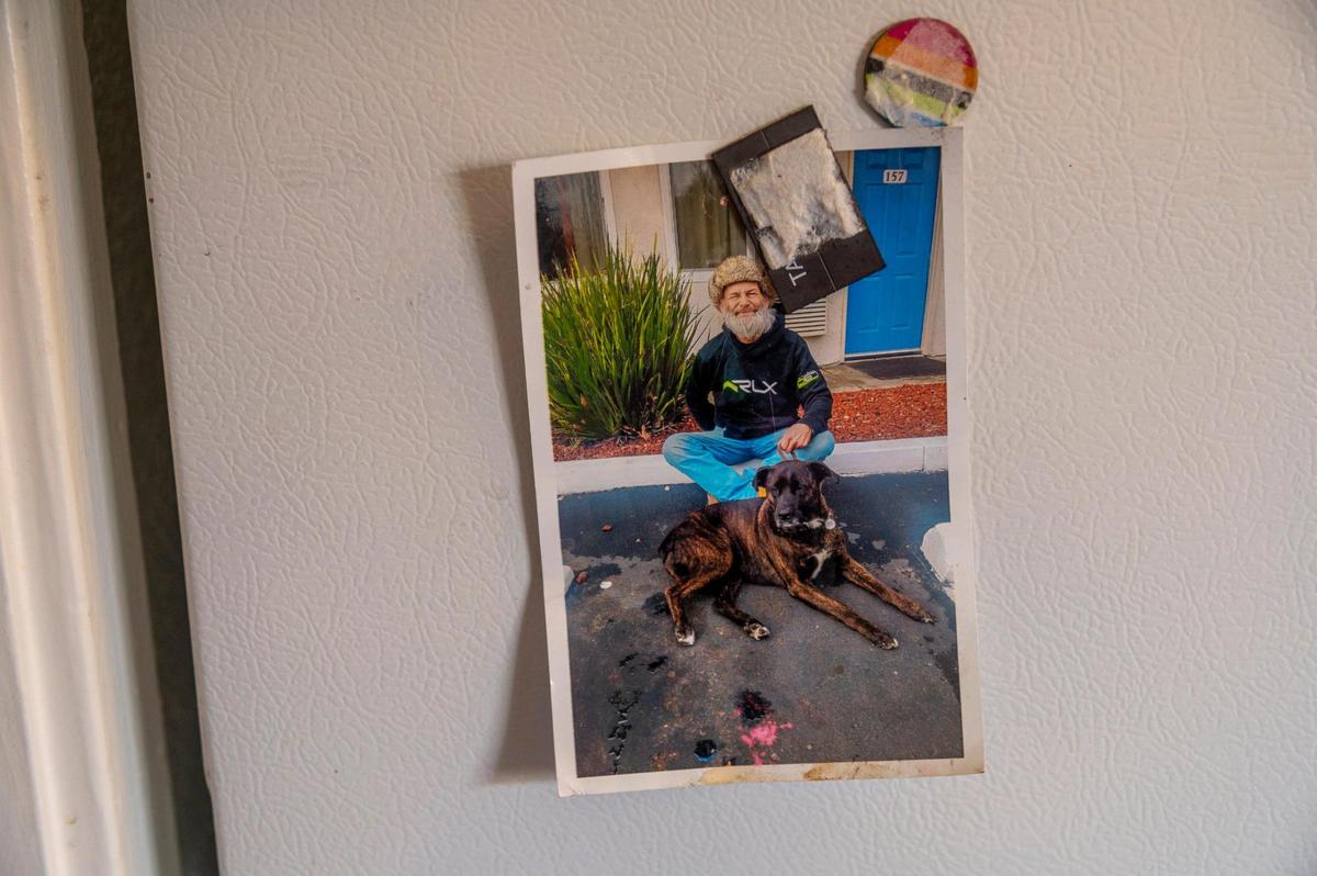 A picture of Jim Wilson when he was homeless on the street with his dog Tokadie is on his refrigerator in his new apartment. Meitra Bozorgzadegan says she met him and his dog at the neighborhood Starbucks and ever since has been his friend, and advocate for his medical and housing issues.