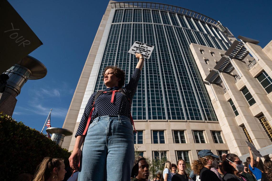Haley Williams, of Sacramento, holds a sign saying “keep your systems for controlling women out of my uterus” while standing with hundreds of others gathered outside the federal courthouse in downtown Sacramento on Tuesday. “They’re coming for uteruses now, it’s the first step, then it’s going to be trans rights, it’s going to be who we can marry, they’re not stopping here,” Williams said. “Anybody who’s not white cis man should be scared.”
