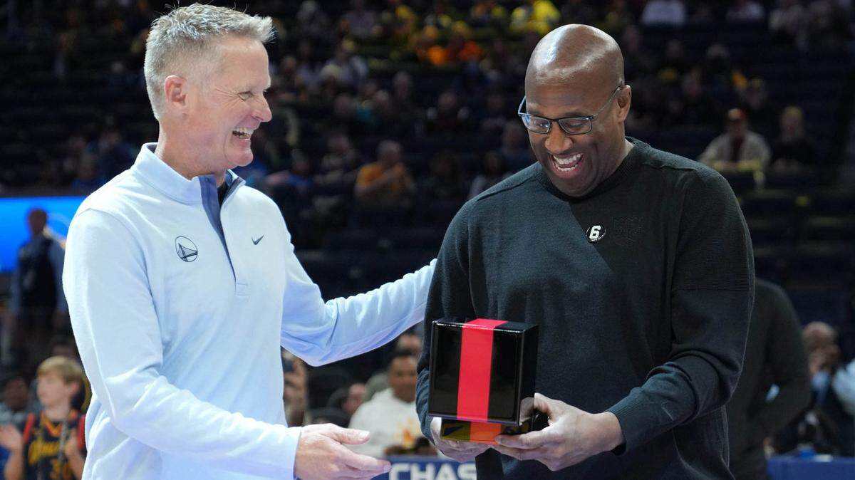 Sacramento Kings head coach Mike Brown, right, receives his championship ring from Golden State Warriors head coach Steve Kerr, left, before the game at Chase Center on Oct. 23, 2022, in San Francisco.