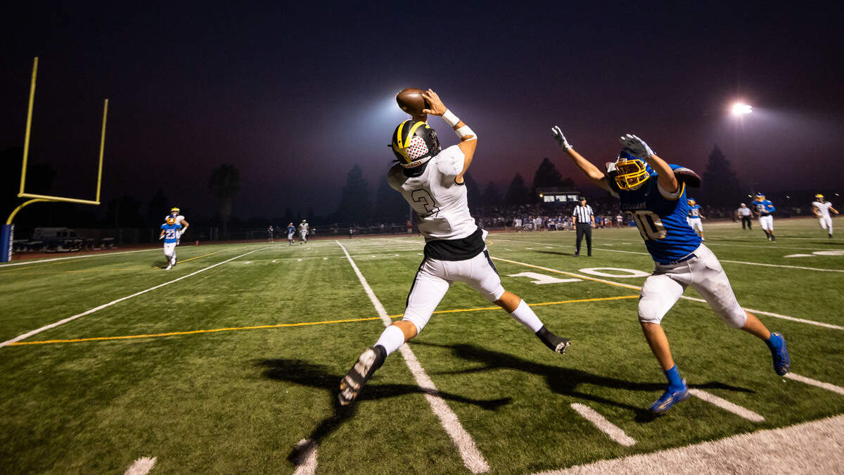 Del Oro’s Gavin Guillen leaps to catch a Ryan Lewis pass and run in for a touchdown, as Del Campo’s Luke Tuter defends, during the second quarter of the high school football game Friday, Aug. 27, 2021, at Del Campo High School in Fair Oaks.