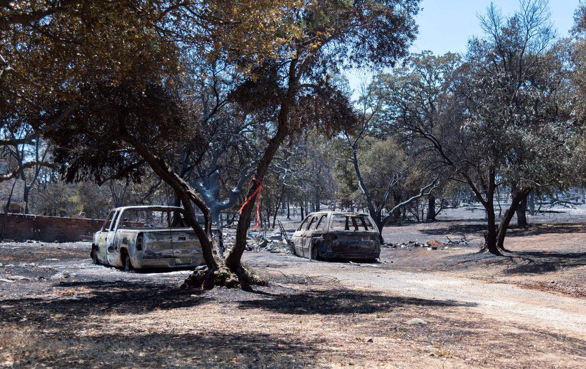 Burned cars sit near a driveway next to rubble from a destroyed home in Oroville on Wednesday, July 3, 2024. A suspect was arrested on suspicion of arson in connection to starting the fire, which destroyed 13 homes and forced about 13,000 people to evacuate.