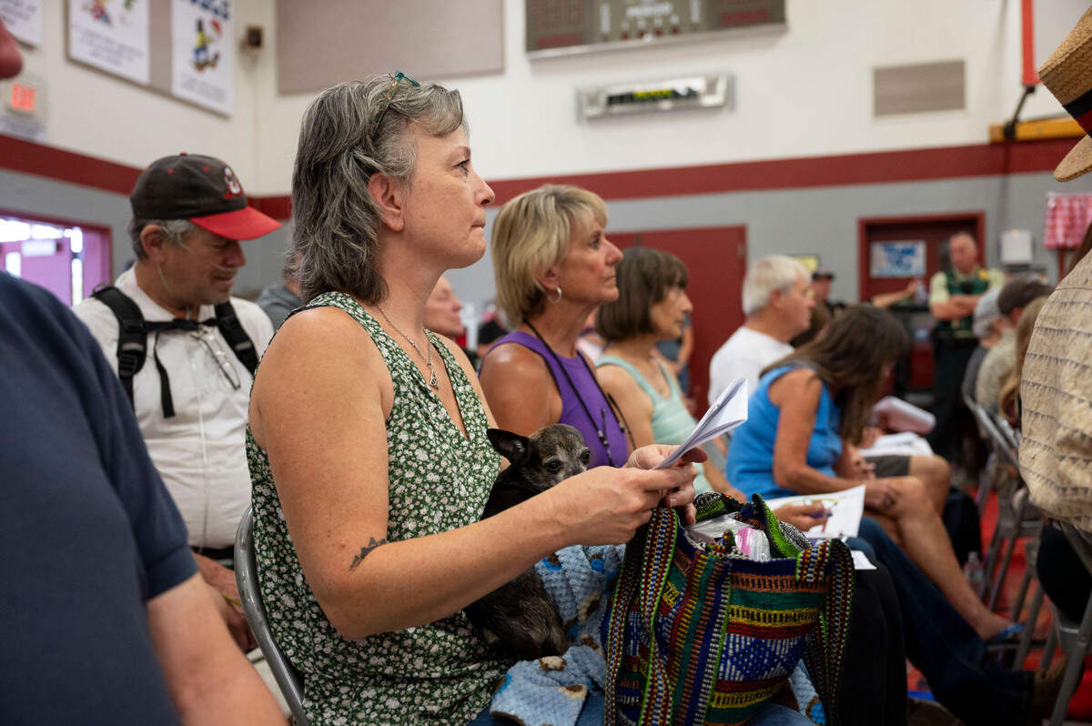 Tammi Baker, who had to evacuate her home in Mosquito, holds her dog Odie during a Crozier Fire town hall meeting at Sutter’s Mill School in Placerville on Sunda.y.