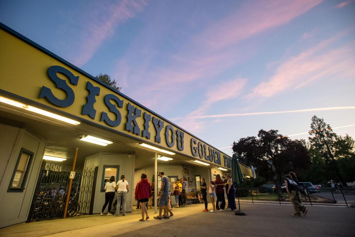 Residents and visitors flow into the Siskiyou Golden Fair as the sun sets and temperatures cool Aug. 9 in Yreka. The Siskiyou County Democrats and Republicans both had a presence on opposite ends of the indoor vendors’ area.