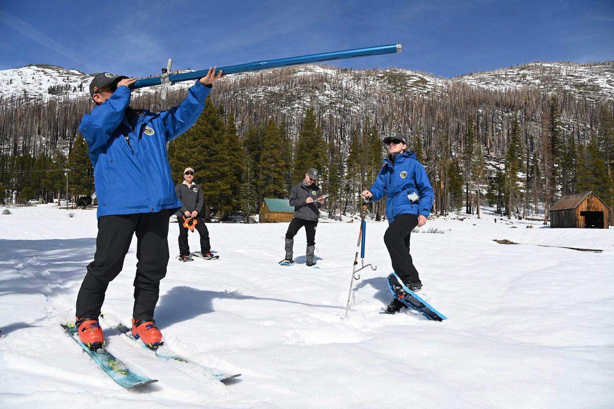 From left, Department of Water Resources staffers Derick Louie, Angelique Fabbiani-Leon, Andy Riesing and Jordan Thoennes conduct the third media snow survey of the season at Phillips Station on Friday, Feb. 27, 2026. The measurement showed statewide snowpack at 66% of average for this date as officials monitor water supplies ahead of the April 1 peak.