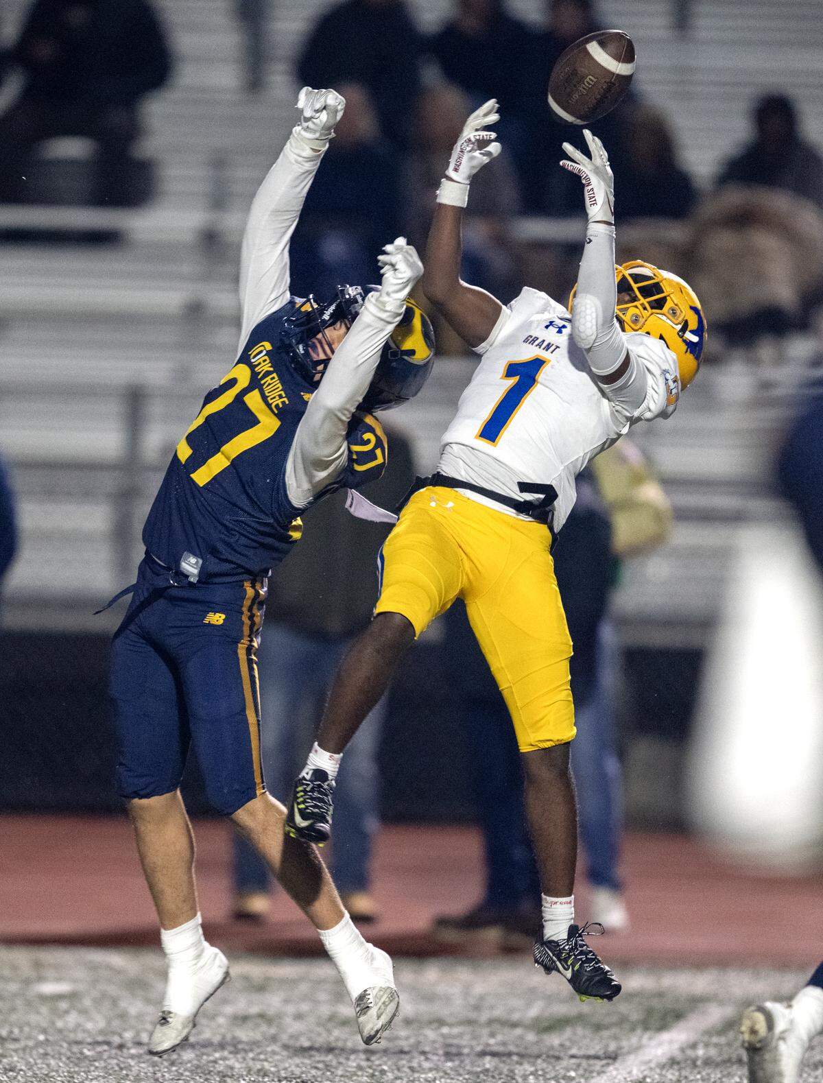 The Grant Pacers' Koby Shabazz (1) juggles a pass with the Oak Ridge Trojans' Jonathan Grosfeld (27) defending in the first half in the CIF Sac-Joaquin Section Division l semifinal football playoff game in El Dorado Hills on Friday, Nov. 21, 2025.