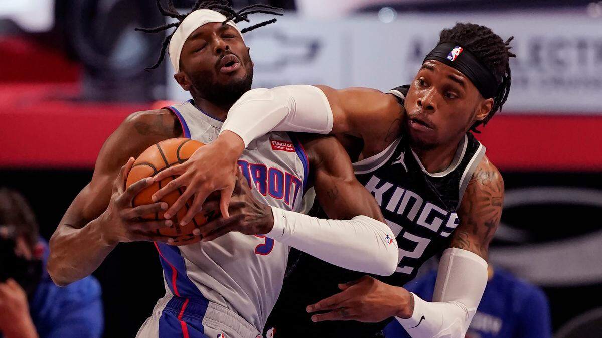 Sacramento Kings center Richaun Holmes (22) reaches in on Detroit Pistons forward Jerami Grant (9) during the first half of an NBA basketball game, Friday, Feb. 26, 2021, in Detroit. (AP Photo/Carlos Osorio)