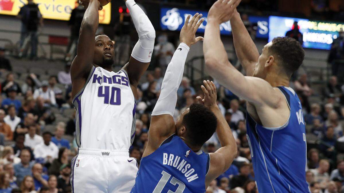 Sacramento Kings forward Harrison Barnes goes up for a shot as Dallas Mavericks’ Jalen Brunson and Dwight Powell, right, defend.