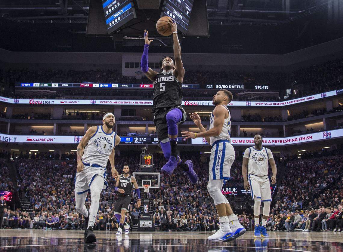 Sacramento Kings guard De'Aaron Fox (5) scores against Golden State Warriors guard Stephen Curry (30) at Golden 1 Center in Sacramento on Feb. 2, 2018.