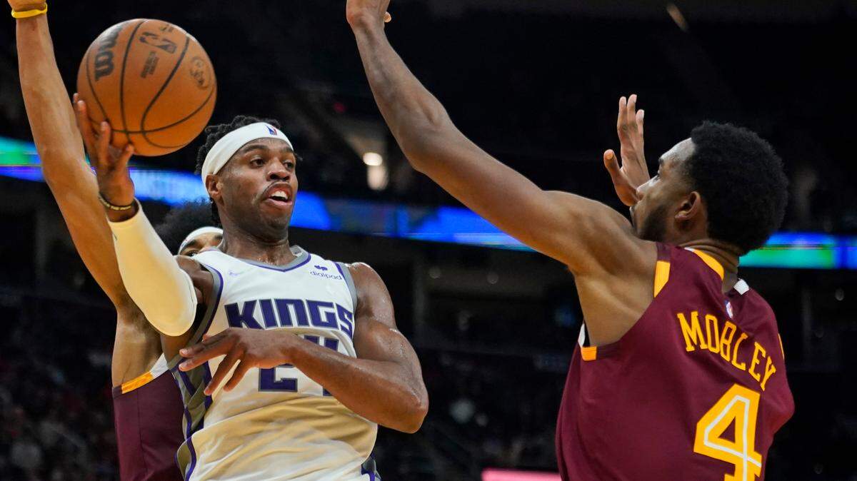 Sacramento Kings’ Buddy Hield (24) passes over Cleveland Cavaliers’ Evan Mobley (4) in the second half of an NBA basketball game, Saturday, Dec. 11, 2021, in Cleveland. (AP Photo/Tony Dejak)