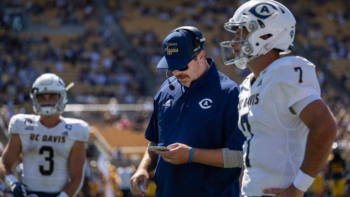 UC Davis Aggies head coach Tim Plough talks with quarterback Miles Hastings (7) during a game against the California Golden Bears on Aug. 31 at Memorial Stadium in Berkeley.