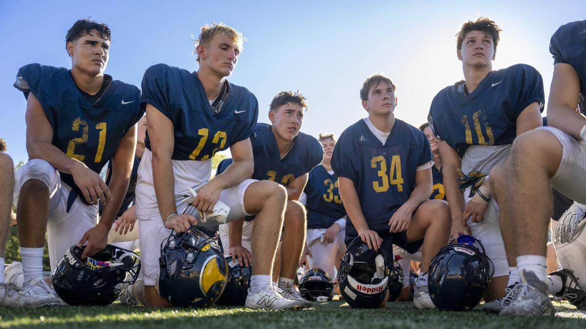 Varsity football players listen to head coach Casey Taylor after a practice at Oak Ridge High School in El Dorado Hills on Tuesday, Aug. 5, 2025.