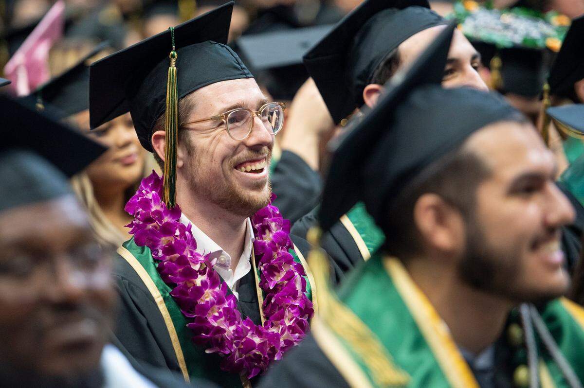 Josiah Andrew Williams smiles as he listens to the speakers during the Sacramento State College of Business commencement on Friday.