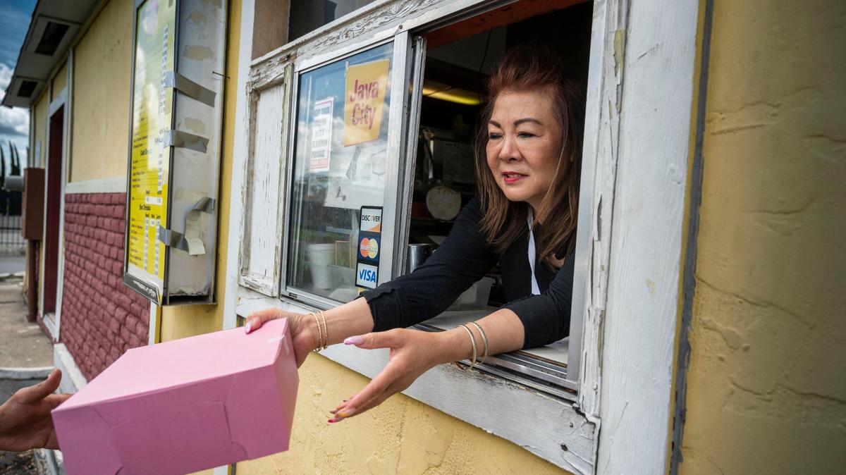 Suzie Hem owner of Baker’s Donuts on Florin Road in Sacramento hands an order of donuts to a driver on Monday. The family-owned shop of 38 years is gearing up for more competition as a new Dunkin’ franchise is expected to open in August and will be the third doughnut shop nearby on ​Florin Road.