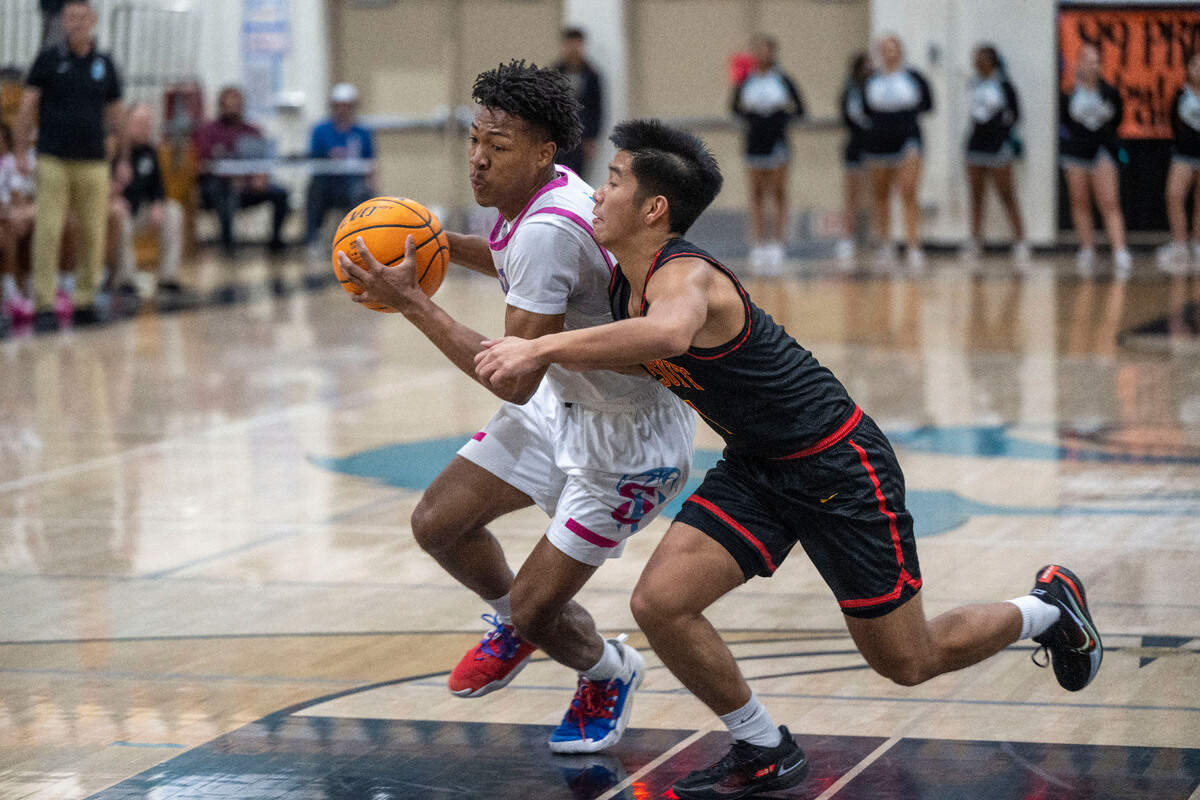 Sheldon guard Muhamad Singleton is defended by Jesuit’s Justin Zara in the first half of the Delta League basketball game against Jesuit on Wednesday night at Sheldon High School.