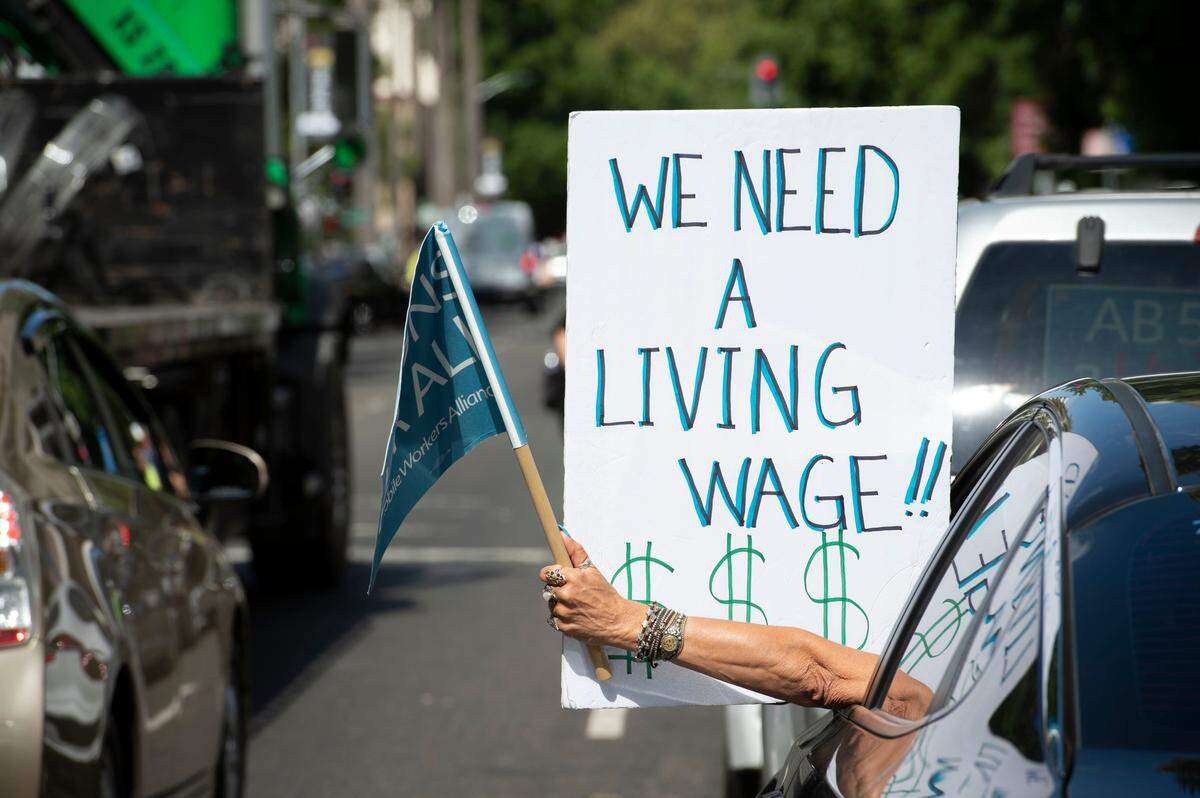 A ride share driver holds a sign from her car as hundreds of Uber and Lyft drivers converged on the California state Capitol on Wednesday, Aug. 28, 2019 to support AB 5. The bill would make it harder for companies to classify workers as independent contractors.