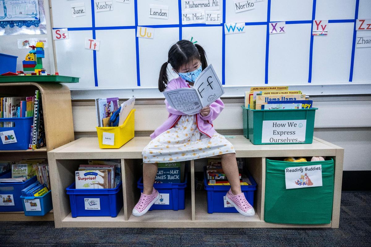 Aubrey Yang, de cuatro años, mira un libro de trabajo para la letra "f" en la Primaria Thomas Kelly.
