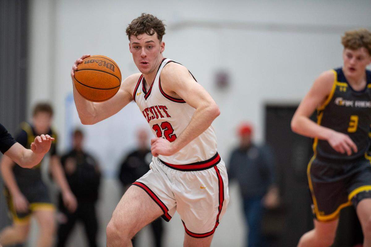The Jesuit Marauders’ Asher Schroeder (22) dribbles up court in the second half against the Oak Ridge Trojans in January. 