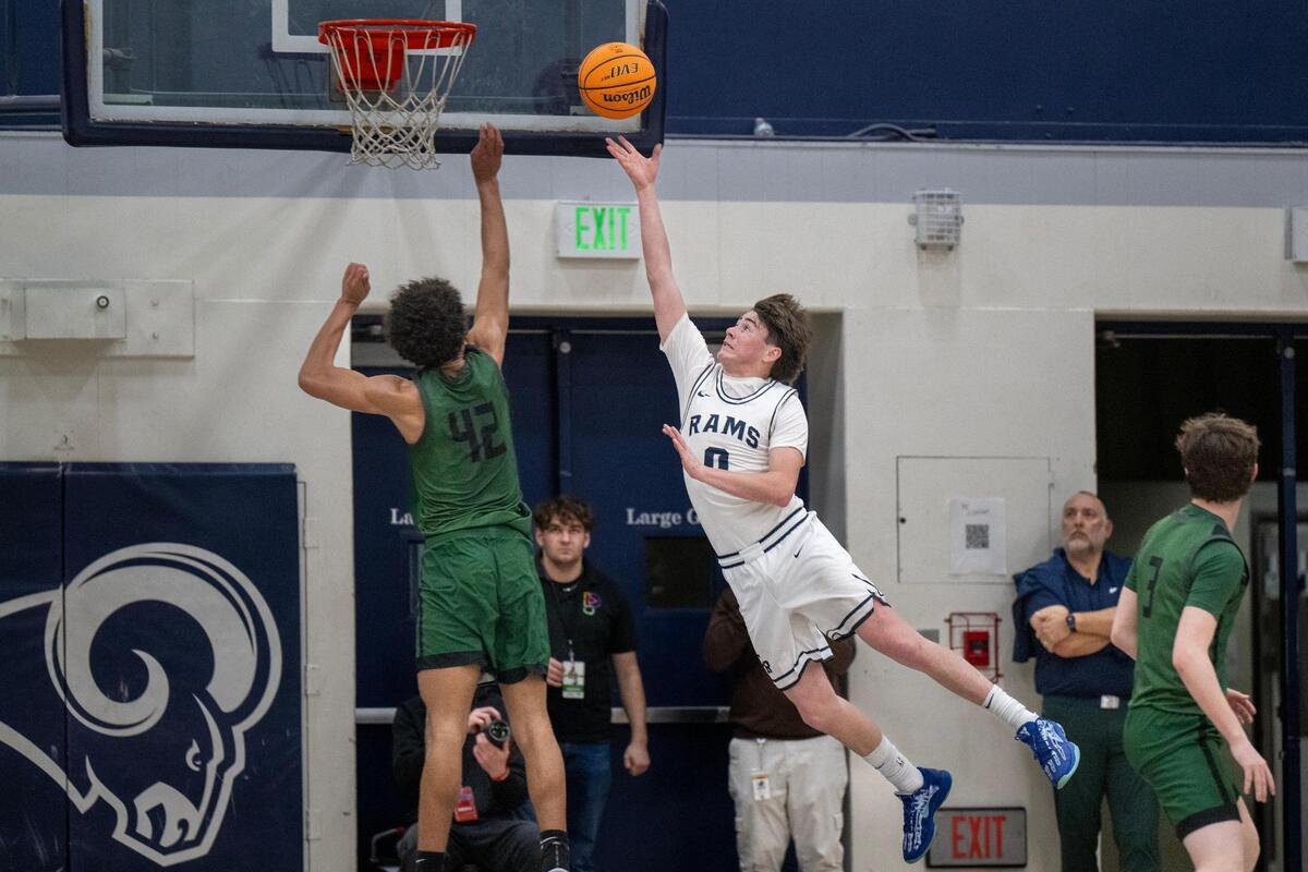 The Casa Roble Rams’ Ace Villegas (0) lays a ball up over the Twelve Bridges Raging Rhinos’ Jaden High (42) in the first half of a CIF Northern California Division IV boys basketball playoff game Tuesday in Orangevale.