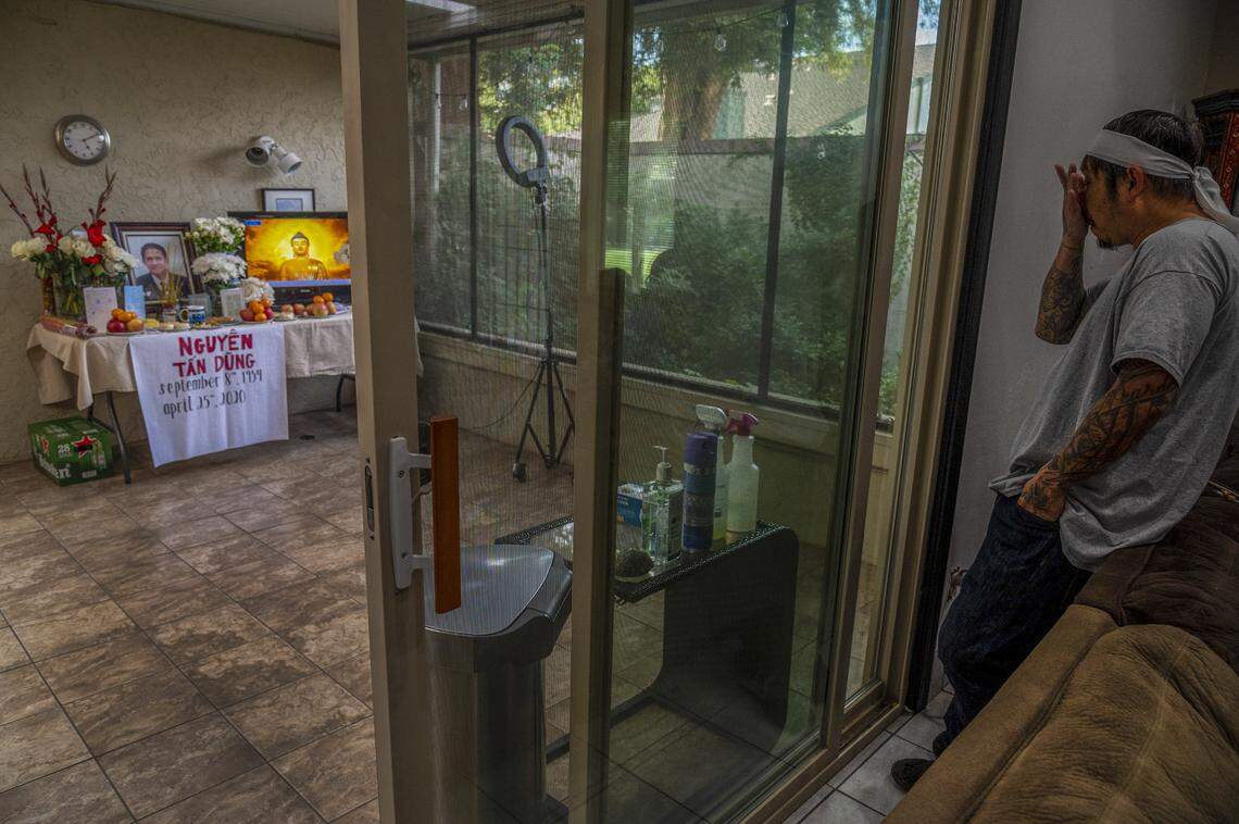 Bao Nguyen, 45, says “I think the whole community would be here,” as he waits for visitors to pay respects in his home, on Monday, May 4, 2020, where he and his wife Trang Nguyen created a prayer room to honor his father Dung Tan Nguyen who died on April 25. If it wasn’t for the coronavirus, at least 15 Buddhist monks would’ve chanted prayers for him, but instead a video of chanting is played. Also in the room is an array of hand sanitizer, gloves, masks and cleaning fluids for those to use during their visit. “It’s kind of a sad way to do it. I’m not used to it. It’s kind of the new way, new normal of our world right now,” said Nguyen who was explaining that only four people will be allowed at the funeral service and that only two people at a time will be allowed to lay flowers on the casket after it is lowered into the grave at the cemetery.