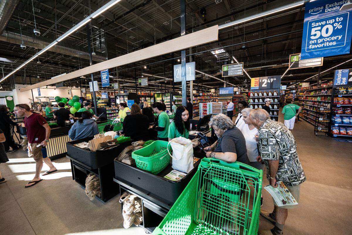 Customers check out after as they attend the grand opening of the first Amazon Fresh in Northern California on Thursday.