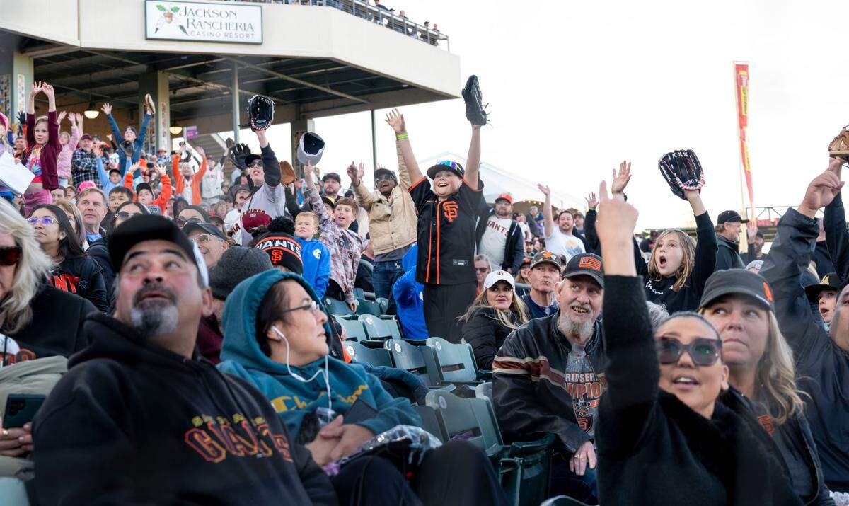 Fans hope to catch free stuff during a giveaway as the San Francisco Giants play the Sacramento River Cats in an exhibition game on March 24.