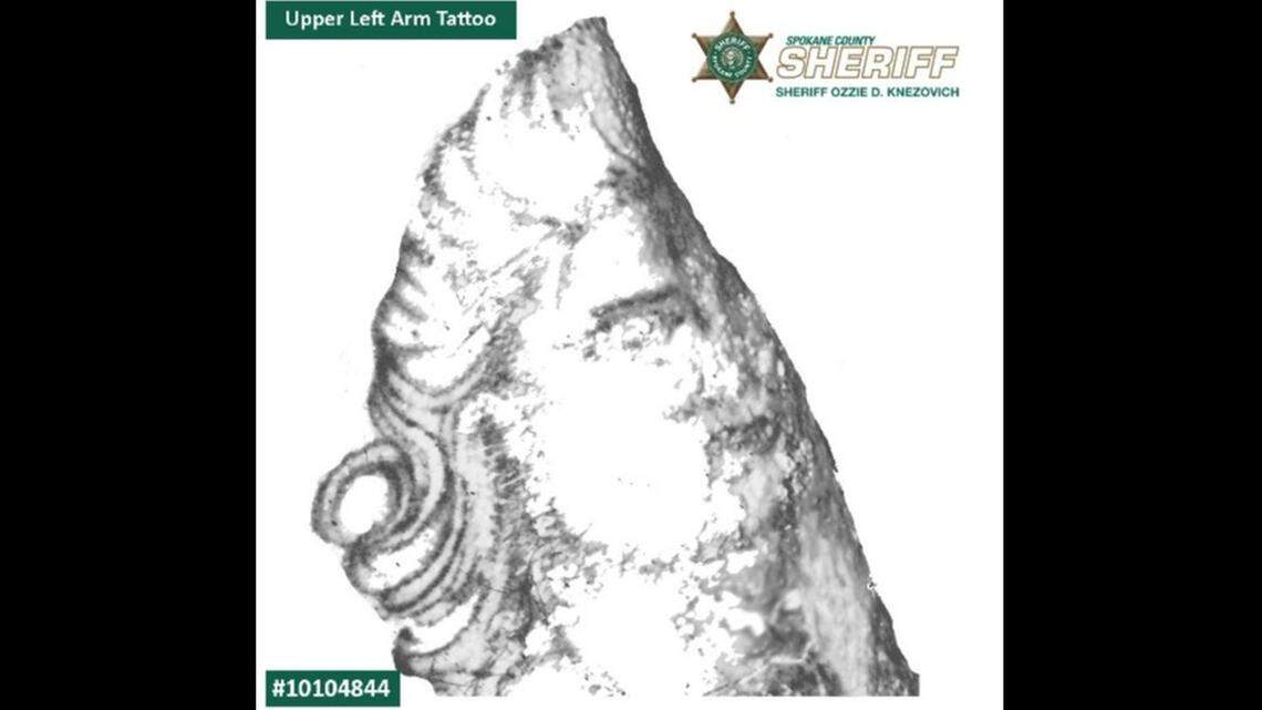 A tattoo the upper-left arm/shoulder depicting what officials believe to be a woman’s face and what appears to be a sombrero-style hat from a different angle.