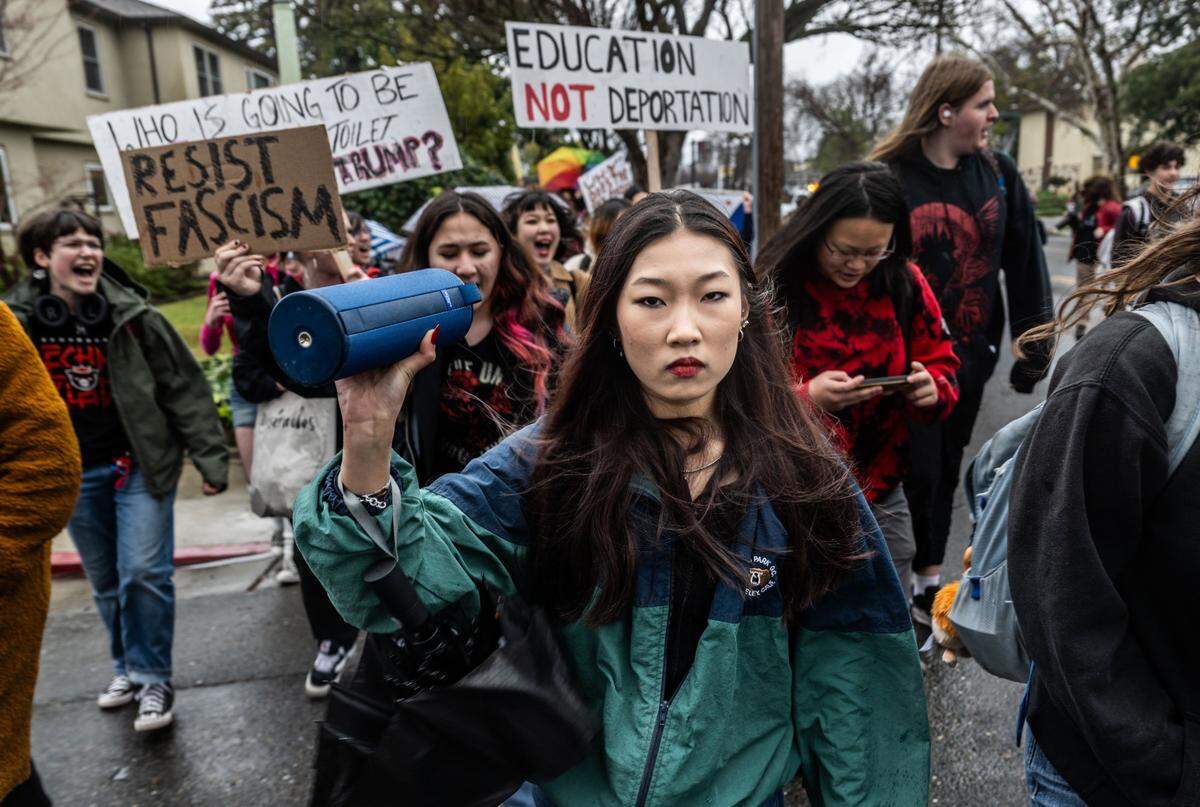 McClatchy High School student Heather Koike marches with students who hold “Resist fascism” and “Education not deportation” signs during a school walk-out on Feb. 6 in Sacramento to protest President Donald Trump’s executive orders.