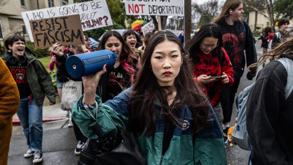 C.K. McClatchy High School student Heather Koike holds a speaker as students behind her hold signs saying “Resist fascism” and “Education not deportation” during a school walkout on Thursday morning in Sacramento to protest President Donald Trump’s executive orders. “The past that Trump wants so bad is Jim Crow,” she said.