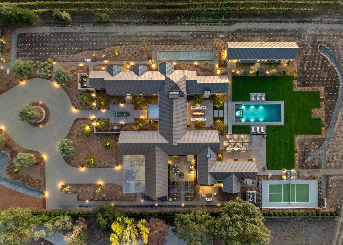 Resort-style living takes center stage with a 20-by-50-foot heated pool, integrated spa, covered loggia and fully outfitted outdoor kitchen for seamless entertaining.