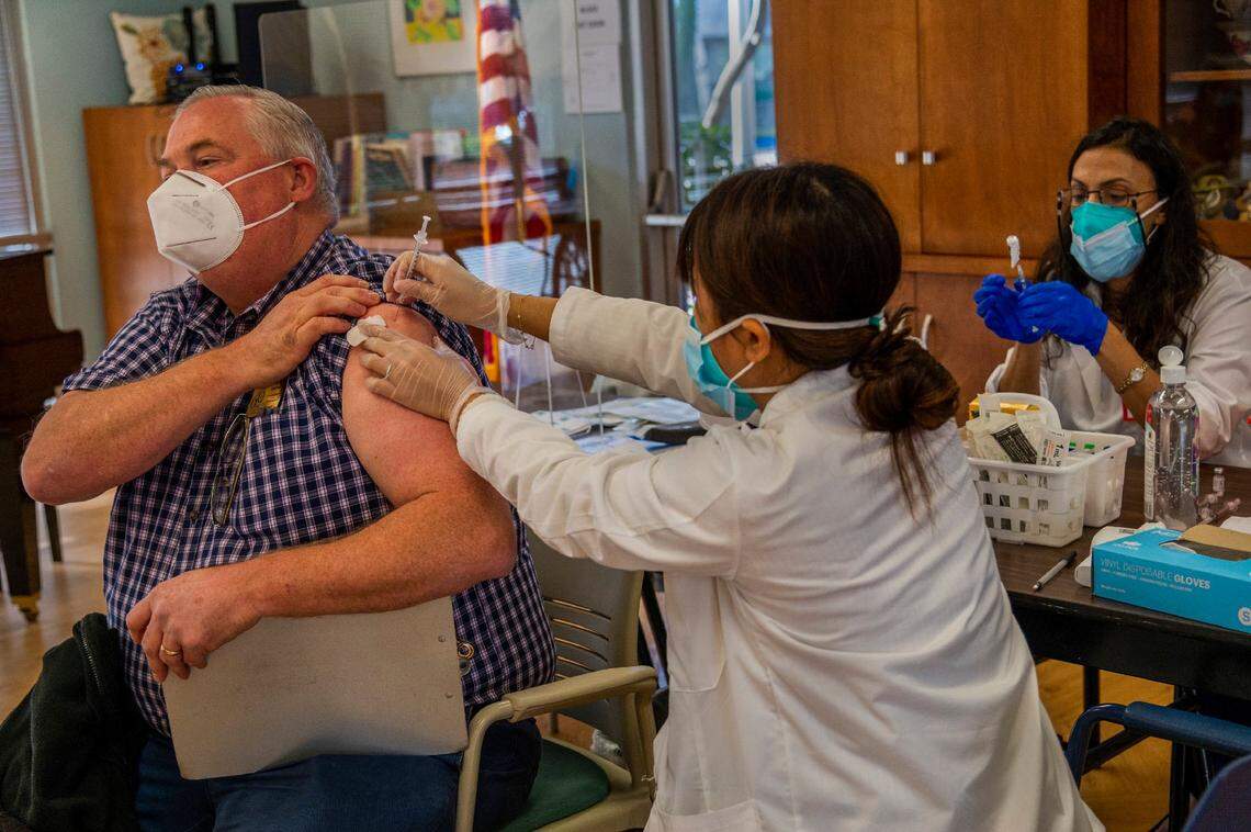Robert Godfrey, executive director of Pioneer House, was among staff and residents that received the COVID-19 vaccines in Sacramento on Jan. 5, 2021. As part of Californias equitable approach to COVID-19 vaccine distribution, nursing home residents and staff are receiving inoculations this week through a government partnership with CVS and Walgreens. CVS pharmacist Ngun Le administered the vaccination as Caroline Nabil, right, prepared another.