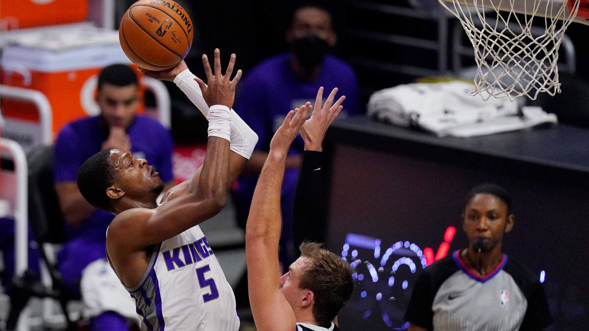 Sacramento Kings guard De’Aaron Fox, left, shoots as Los Angeles Clippers guard Luke Kennard defends during the first half of an NBA basketball game Sunday, Feb. 7, 2021, in Los Angeles. (AP Photo/Mark J. Terrill)