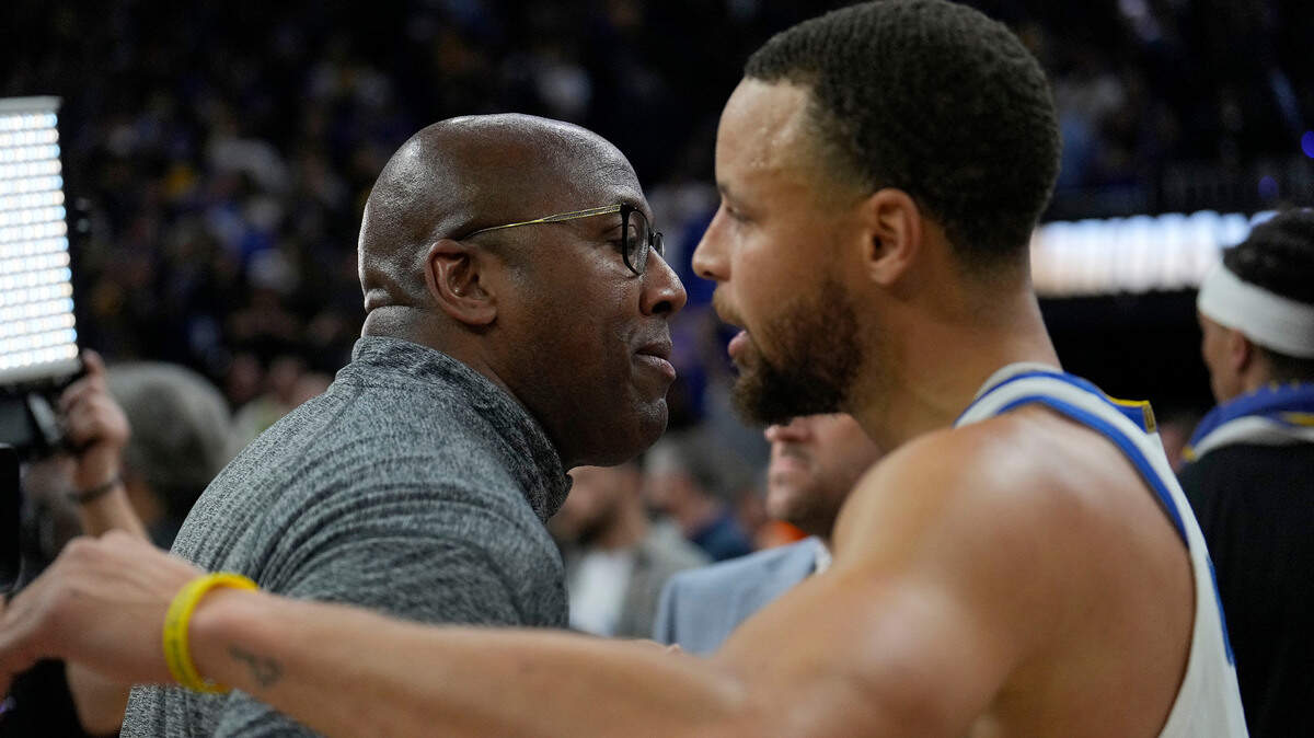 Golden State assistant coach Mike Brown, left, hugs Stephen Curry after a 101-98 victory against the Memphis Grizzlies on Monday, May 9, 2022.