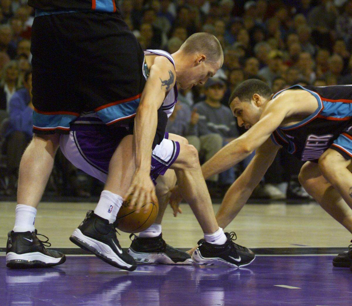 Kings guard Jason Williams and Grizzles guard Mike Bibby grab at the ball during the second half at Arco Arena in 1999.