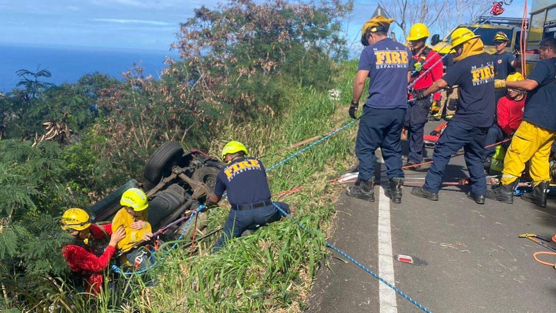 A crash left a 71-year-old woman and her dog hanging off a 200-foot cliff in a vehicle on Maui, Hawaii rescuers say.