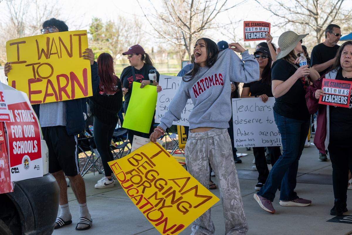 Natomas High School senior Ashlyn Aradhna, center, holds a sign at a rally during the first ever Natomas educators strike on Tuesday, March 10, 2026, in Sacramento. 