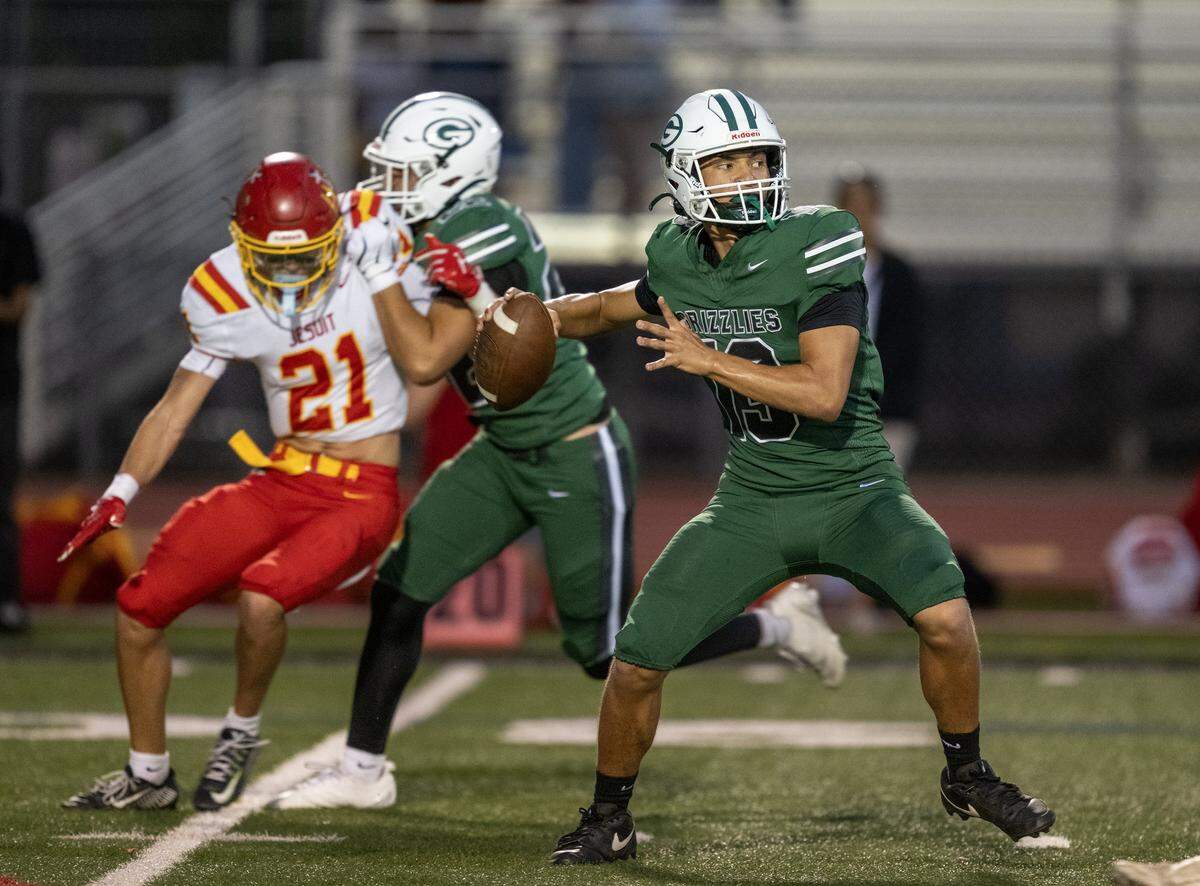 The Granite Bay Grizzlies' Dominic Cattolico (13) drops back to pass in the first half against the Jesuit Marauders on Friday in Granite Bay.