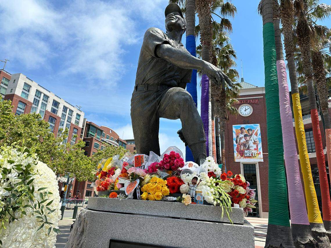 Flowers accumulate at the base of the Willie Mays statue outside Oracle Park in San Francisco on Wednesday.