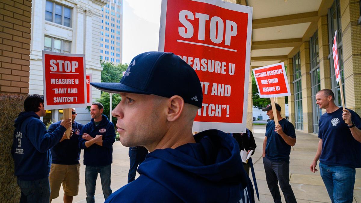 Sacramento firefighter Brandon Doughty from station No. 19 holds a sign protesting proposed Measure U spending in front of City Hall on on Tuesday, May 21, 2019 in Sacramento.