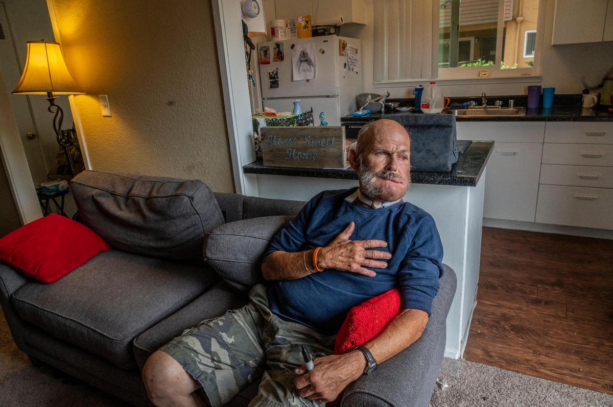 After his throat surgery for cancer Jim Wilson can’t talk but communicates with hand signals, his iPad and writing on a message board on Friday June 12, 2020. Here he signals a heartfelt thanks to his friend Meitra Bozorgzadan, who helped him find this new permanent home after living on the streets for the past 16 years.