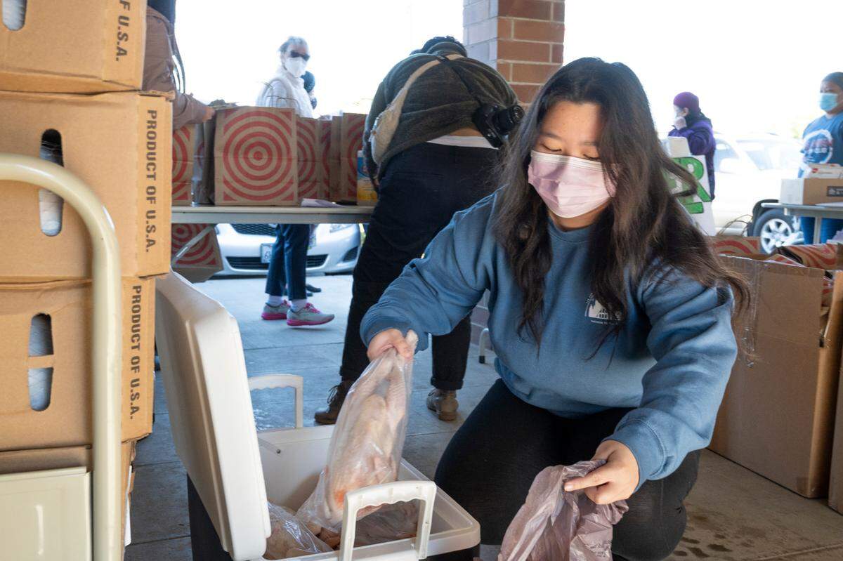 Volunteer Grace Yang bags chicken to distribute at the Stockton Boulevard Partnership in South Sacramento on Saturday morning Nov. 20. Over 70 seniors of lu Mien descent received food on this day.