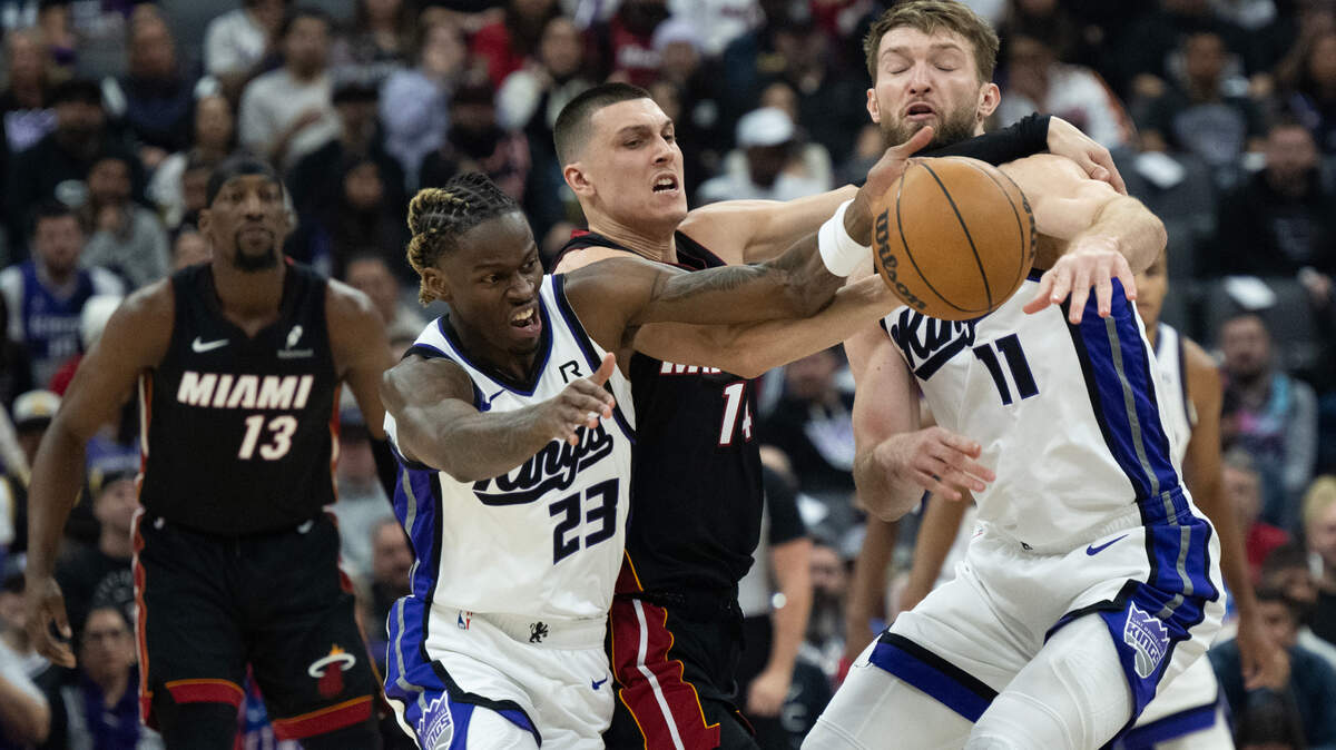 Sacramento Kings guard Keon Ellis (23) and center Domantas Sabonis (11) struggle with Miami Heat guard Tyler Herro (14) for the ball during an NBA game at Golden 1 Center on Monday.