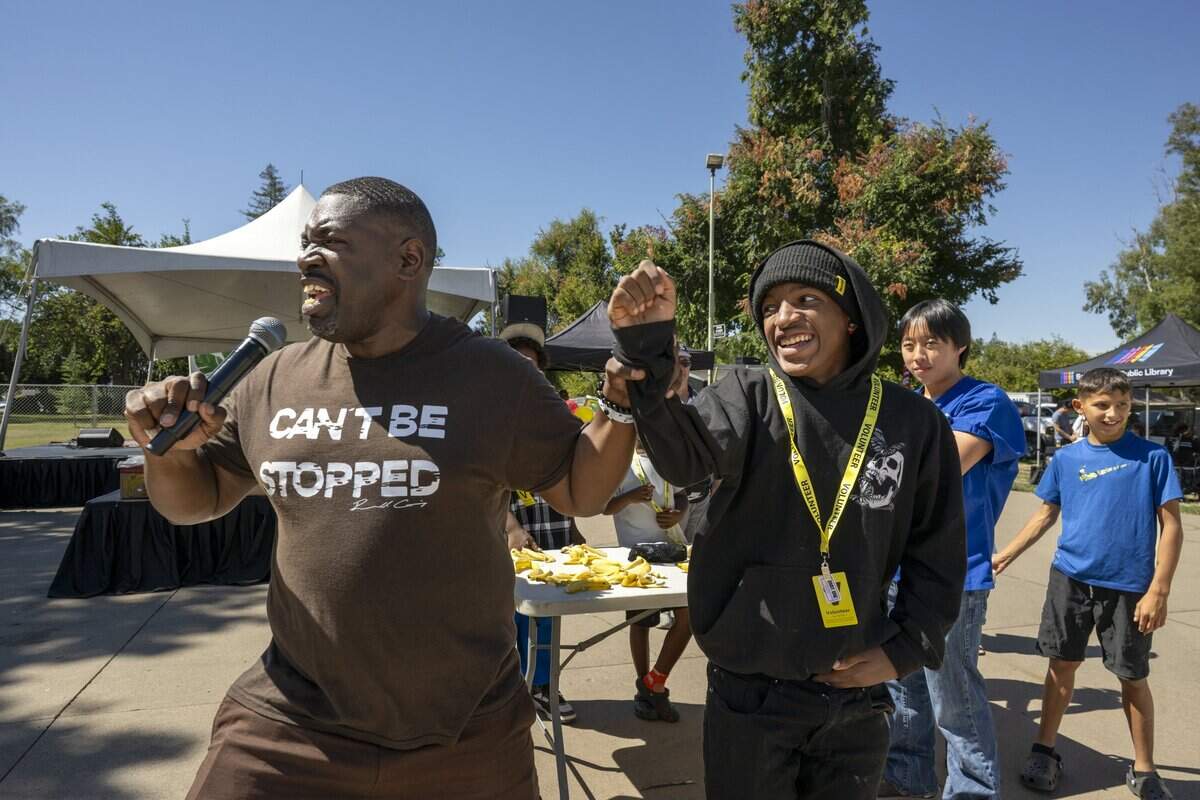 Russell Cummings celebrates Josh Tarver, winner of the banana-eating contest, at the Banana Festival in Land Park on Saturday, Aug. 15, 2026.